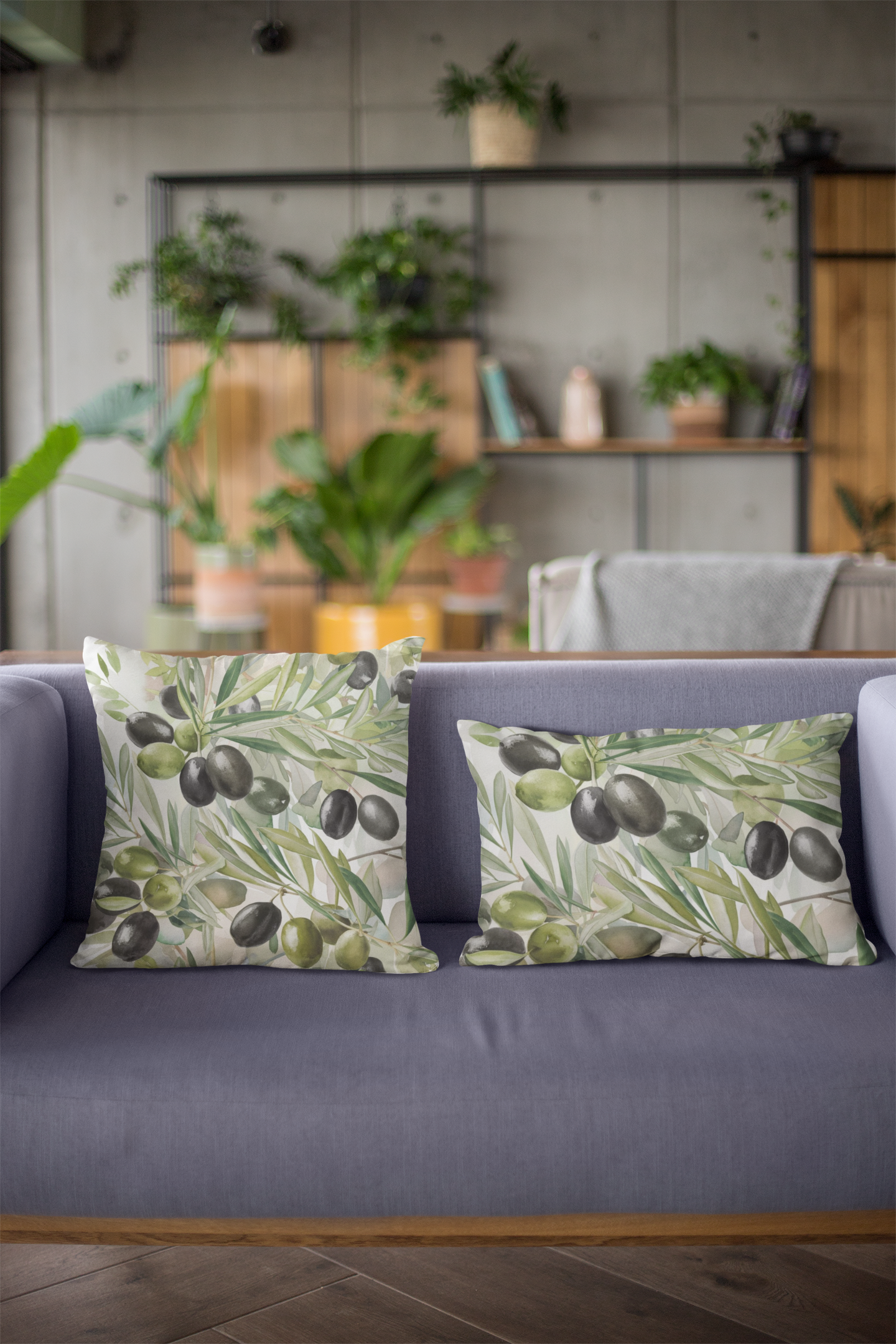 Two decorative pillows with olive branch illustrations on a purple sofa, set in a modern living room with green plants.